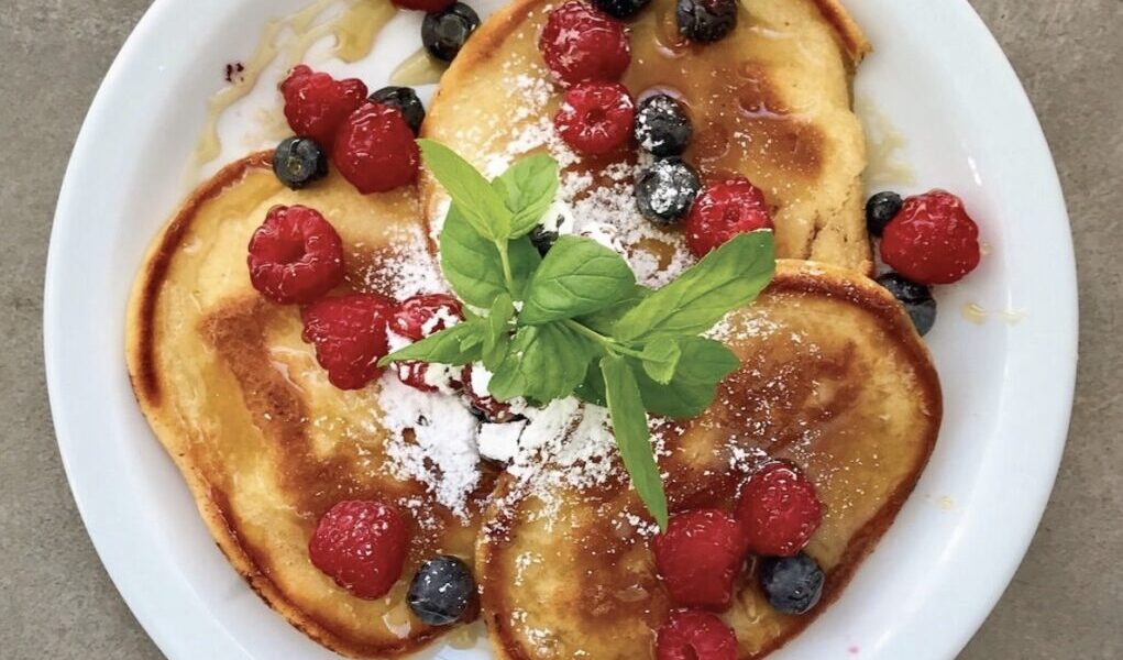 Pancakes z owocami leśnymi to doskonałe połączenie puszystych naleśników z mąki, mleka, żółtek i piany z białek jajek i owoców leśnych. Całość dopełnia słodki syrop klonowy. I jak tu nie kochać takiego jedzenia?
