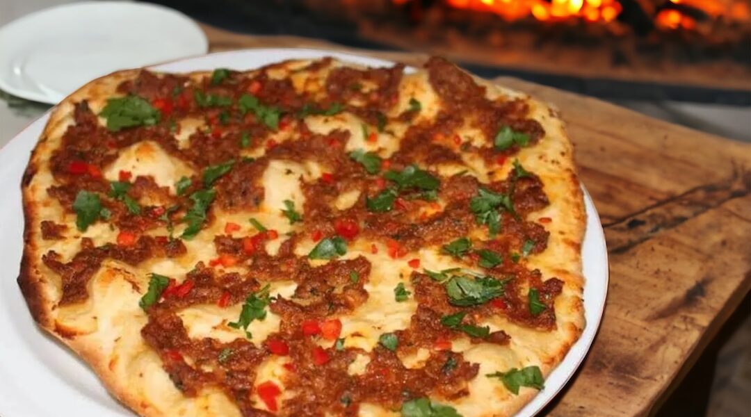 Lahmacun, czyli turecka pizza wypełniona mielonym duszonym mięsem z przyprawami oraz papryką i pomidorem.