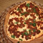 Lahmacun, czyli turecka pizza wypełniona mielonym duszonym mięsem z przyprawami oraz papryką i pomidorem.