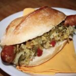 Hot dog po węgiersku to znakomicie zbilansowany szybki posiłek przygotowany z chrupiącej bułki, paprykowanej kiełbaski i zdrowych kiszonek.