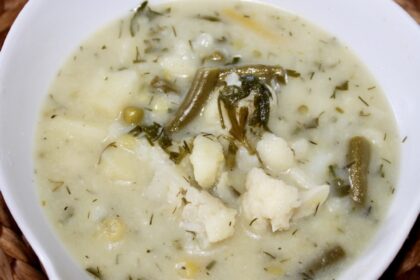 Letnia zupa jarzynowa na bulionie ze skrzydełek kurczaka przyrządzona z dodatkiem kalafiora, ziemniaków i fasolki szparagowej zabielona kwaśną śmietaną.