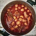 grecki gulasz z królika duszonego w sosie pomidorowym z cebulkami perłowymi i cynamonem