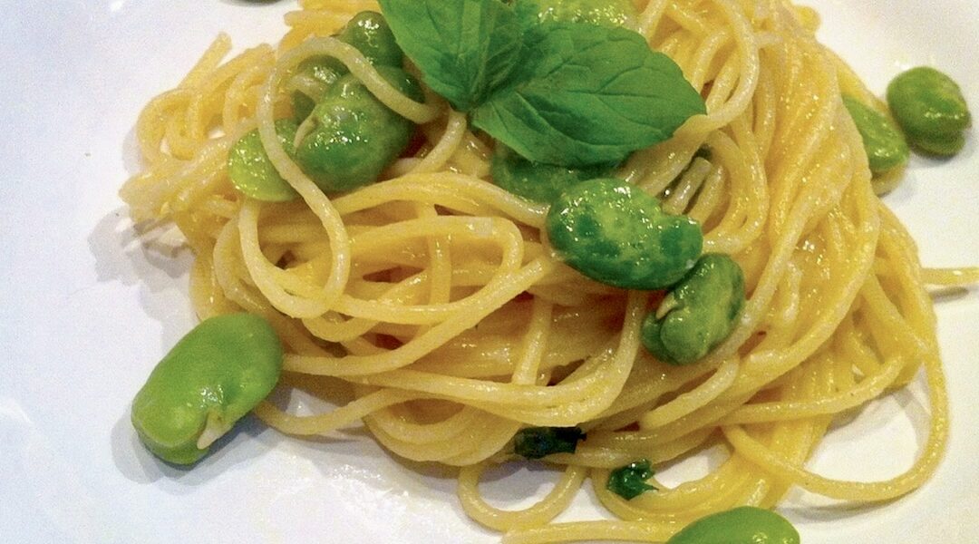 Makaron spaghetti z gotowanym, a następnie podsmażonym na oliwie bobem i świeżą miętą.