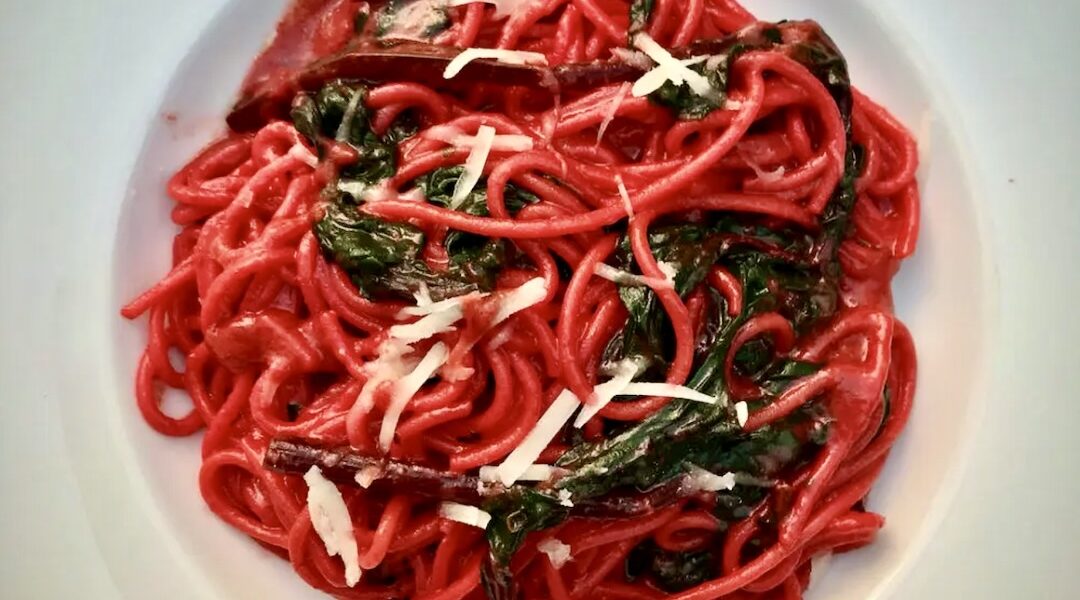 Makaron spaghetti przygotowany z aromatycznym sosem pesto z gotowanego buraka z dodatkiem startego sera, oliwy, czosnku i chilli.