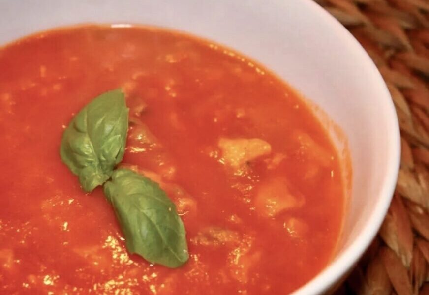 Zupa pomidorowa na wywarze jarzynowym z dodatkiem domowego przecieru pomidorowego i świeżej bazylii podana z lanym ciastem.