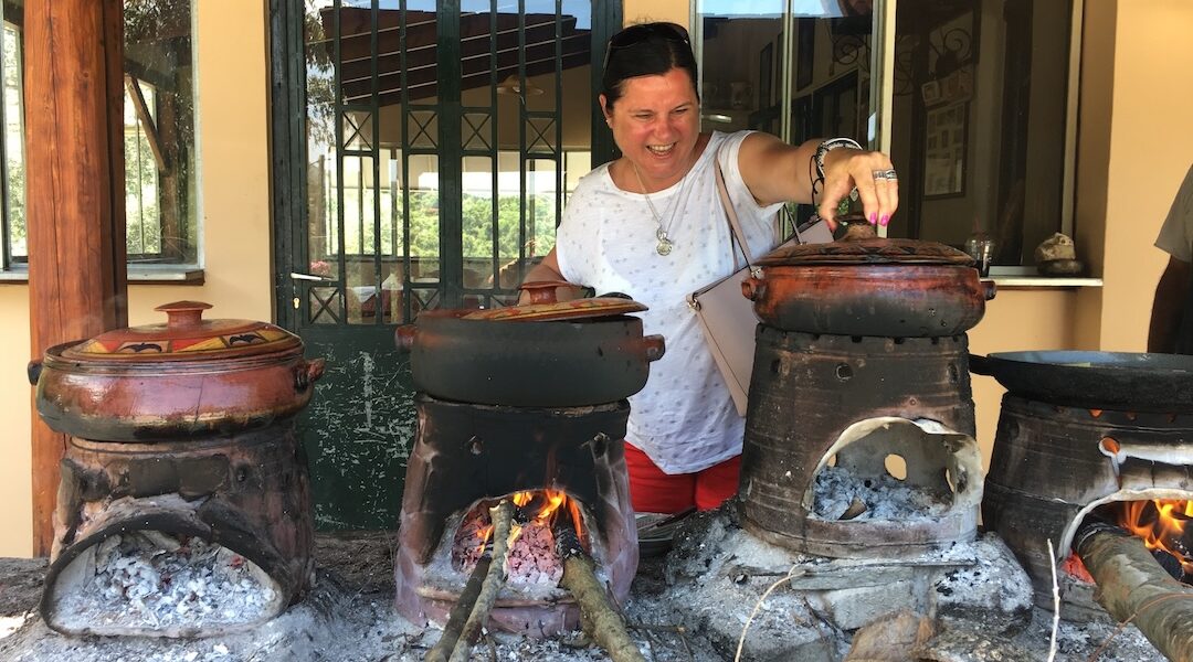 joanna blog kuchnia tomka sprawdza zawartość glinianych naczyń, w których gotują się na ogniu potrawy kuchni kreteńskiej
